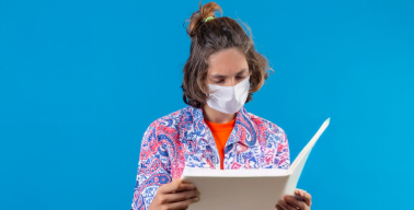 jovem usando máscara descartável lendo um jornal